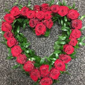 Punaisista ruusuista tehty sydämenmuotoinen kukka-asetelma